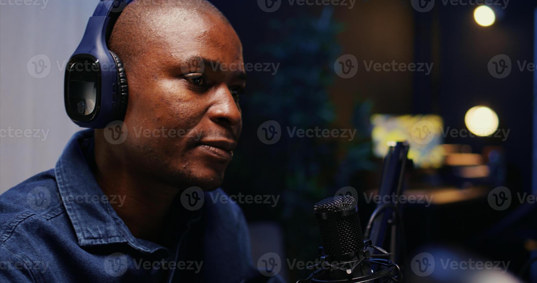 Close up shot of BIPOC host recording entertaining discussion during podcast filmed in apartment studio. Happy presenter uses professional equipment to produce comedy internet show photo