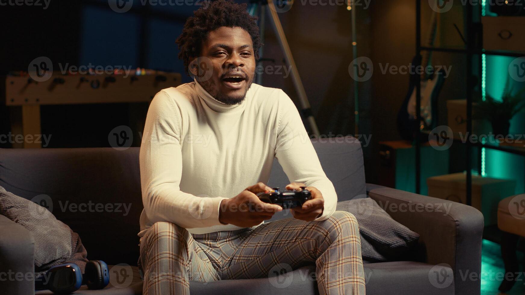 Man arriving in gaming room, ready to play videogame on console with his friends. Gamer using joypad controller to engage in multiplayer games with internet teammates, relaxing at home photo