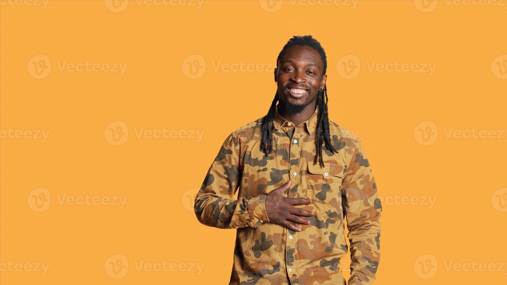 Confident male model laughing at jokes on camera, feeling happy and enjoying good times in studio. African american man acting silly and amusing over memes, having fun with laughs. photo