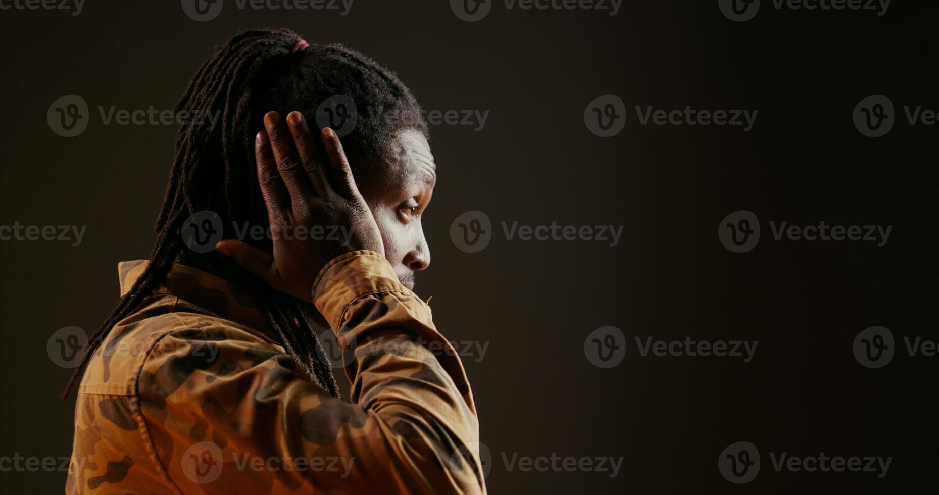 Young adult showing three wise monkeys symbol over black background, advertising the principle to see no evil, hear no evil, speak no evil. Male model covering his mouth, eyes and ears. photo