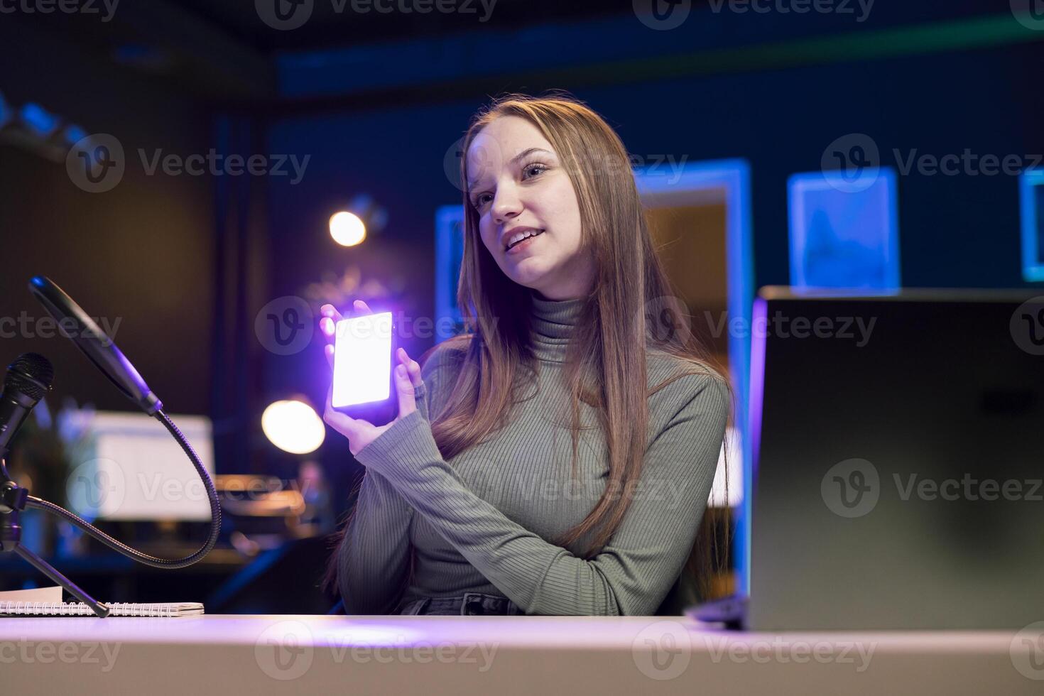 Influencer in studio using camera to capture live broadcast, reviewing mini RGB lights. Online show host filming electronics haul, presenting wireless LED lighting device to viewers photo