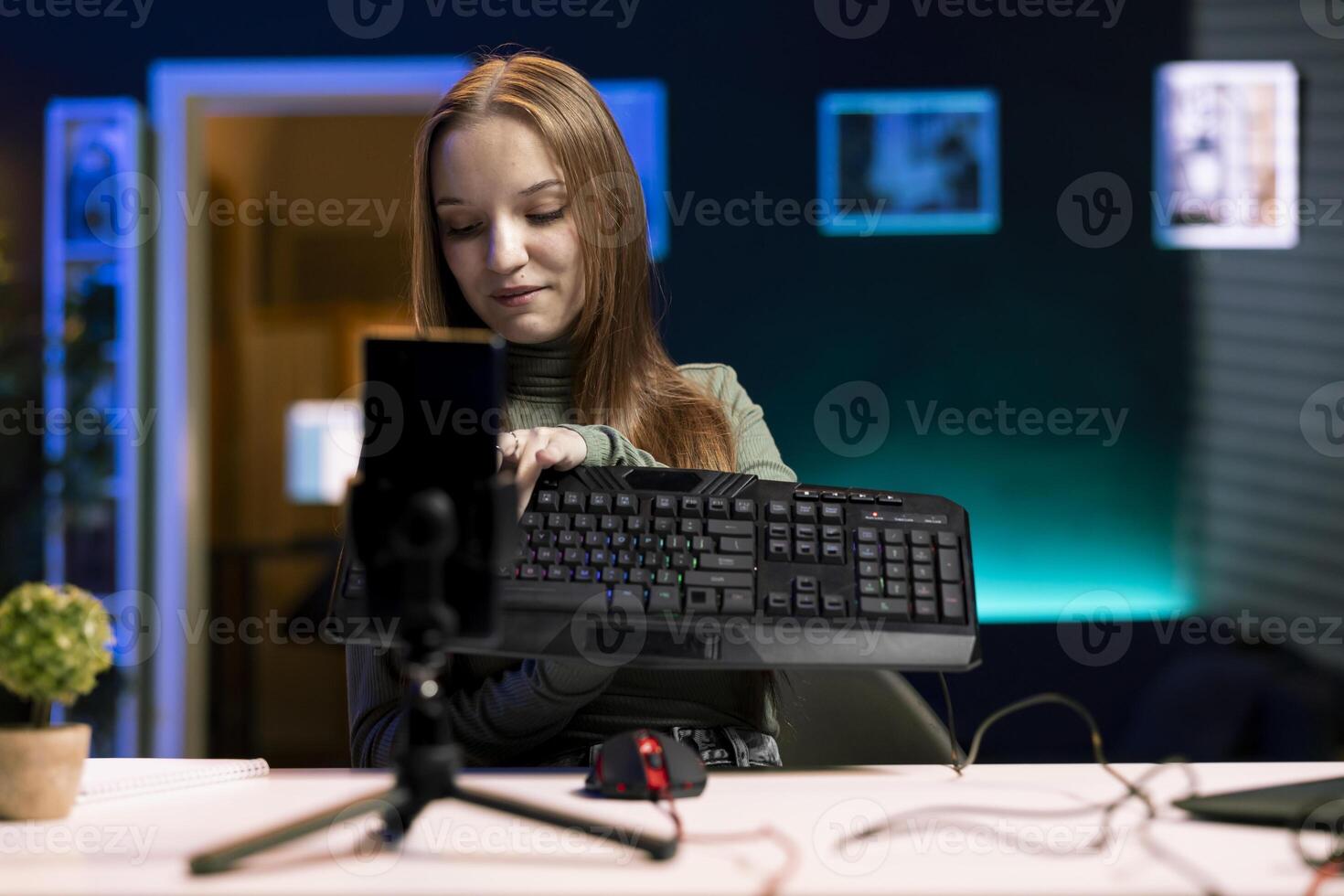 Content creator typing on mechanical keyboard while doing review in personal studio to see if price is justified. Technology guru showcasing computer peripheral features to fans photo