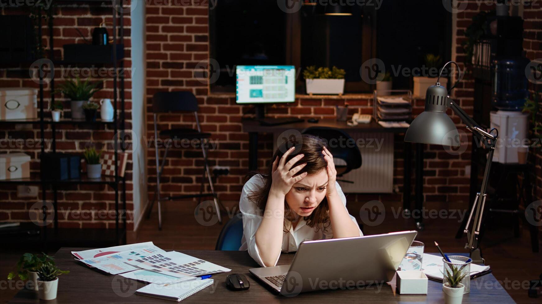Businesswoman working on company project overnight, feeling frustrated, putting head in hands. Upset employee sighing while looking over figures on laptop screen, exasperated by failure photo