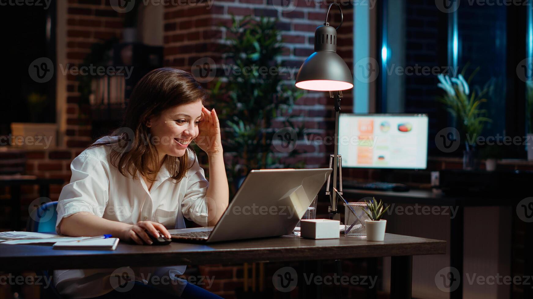 Happy employee reading email on laptop received from customer, excited after managing to secure lucrative deal for company. Businesswoman celebrating finalizing agreement with client, camera B photo