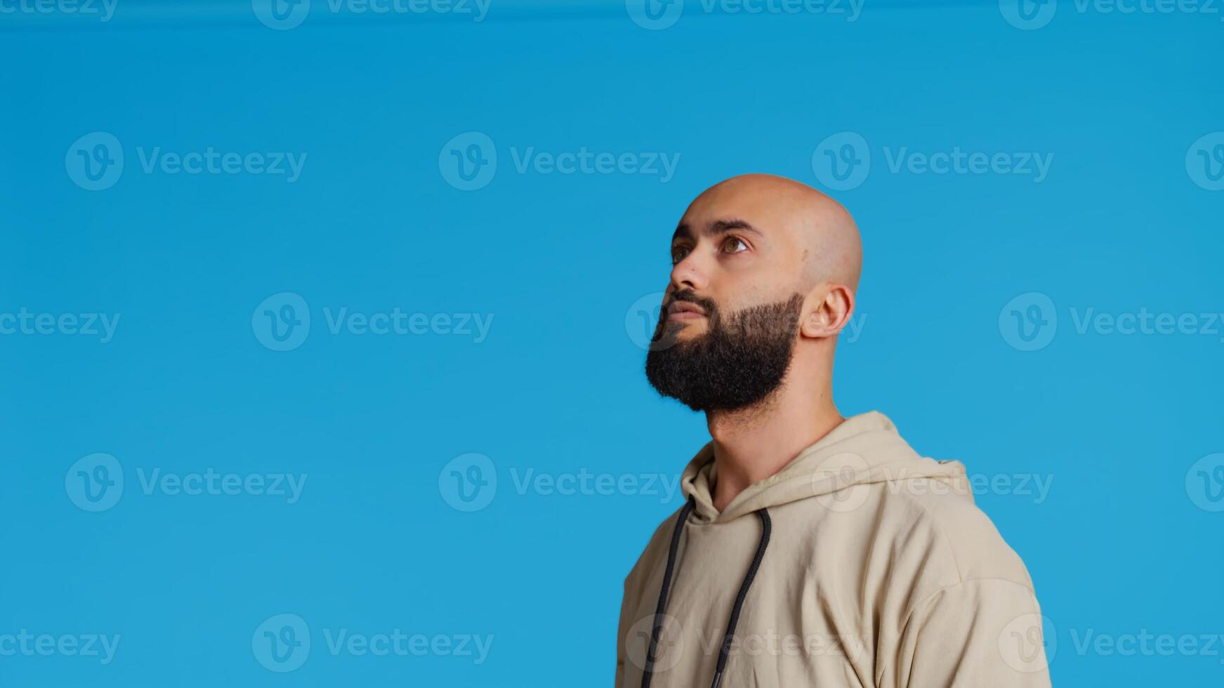 Arab man exploring artificial intelligence with holograms, examining holographic projection of a slideshow in studio. Middle eastern person looks at graphic image on holograph. Camera 2. photo