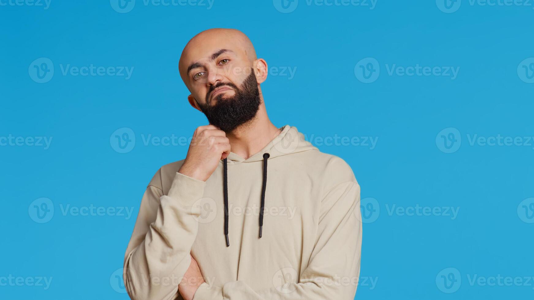Middle eastern person thinking about a thing on camera, acting pensive and puzzled while trying to make a decision. Arab guy acting thoughtful and unsure about a question. Camera 2. photo