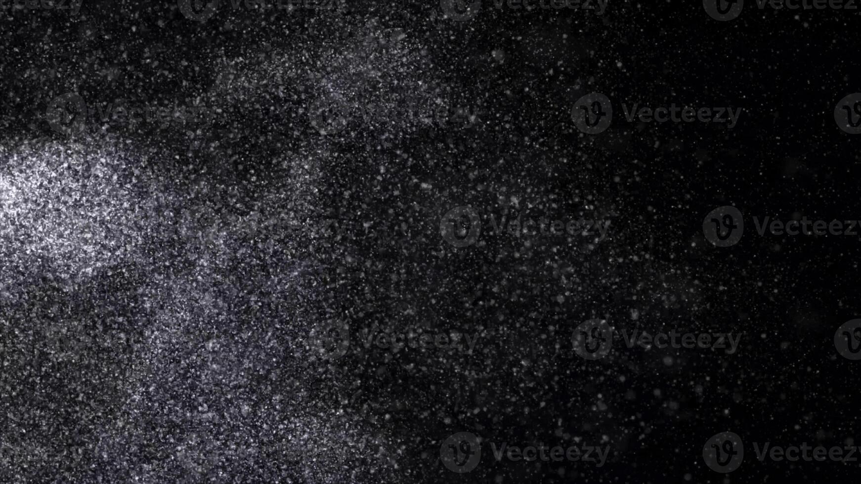 Abstract animation of small white particles exploding isolated on black background. Animation. White dry inks dust flying into the sides in the dark. photo