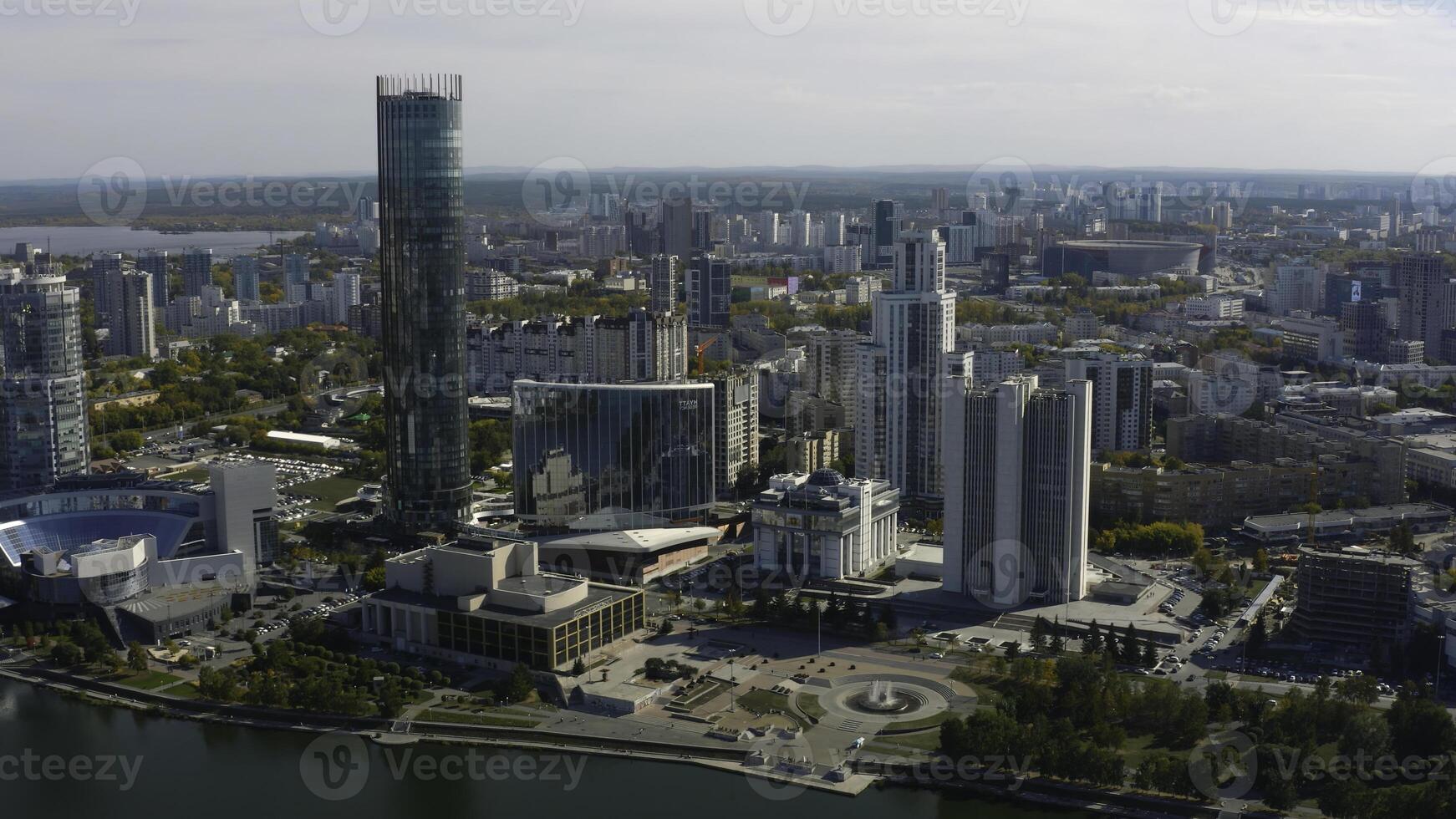 Top view of beautiful city with high-rise buildings in summer. Stock footage. Landscape of modern city from bird's-eye view. Beautiful sunny day in modern city with skyscrapers and river in summer photo