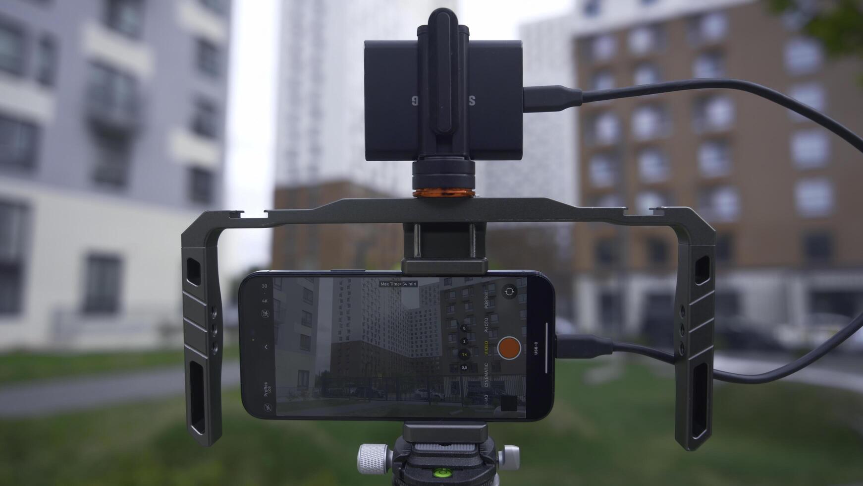 China, Beijing - September 15, 2023. Connecting professional stabilizer to phone for shooting. Action. New iPhone 15 pro with additional gadgets for professional shooting. Stabilizer and screen with photo