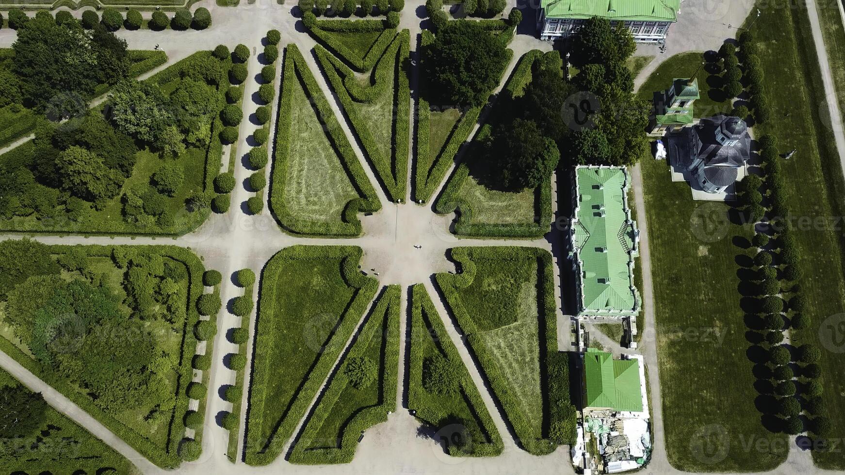 Top view of royal garden with patterns and ancient buildings. Creative. Amazing beauty of garden pattern and trails of royal palace. Territory of old rich estate with garden on sunny summer day photo