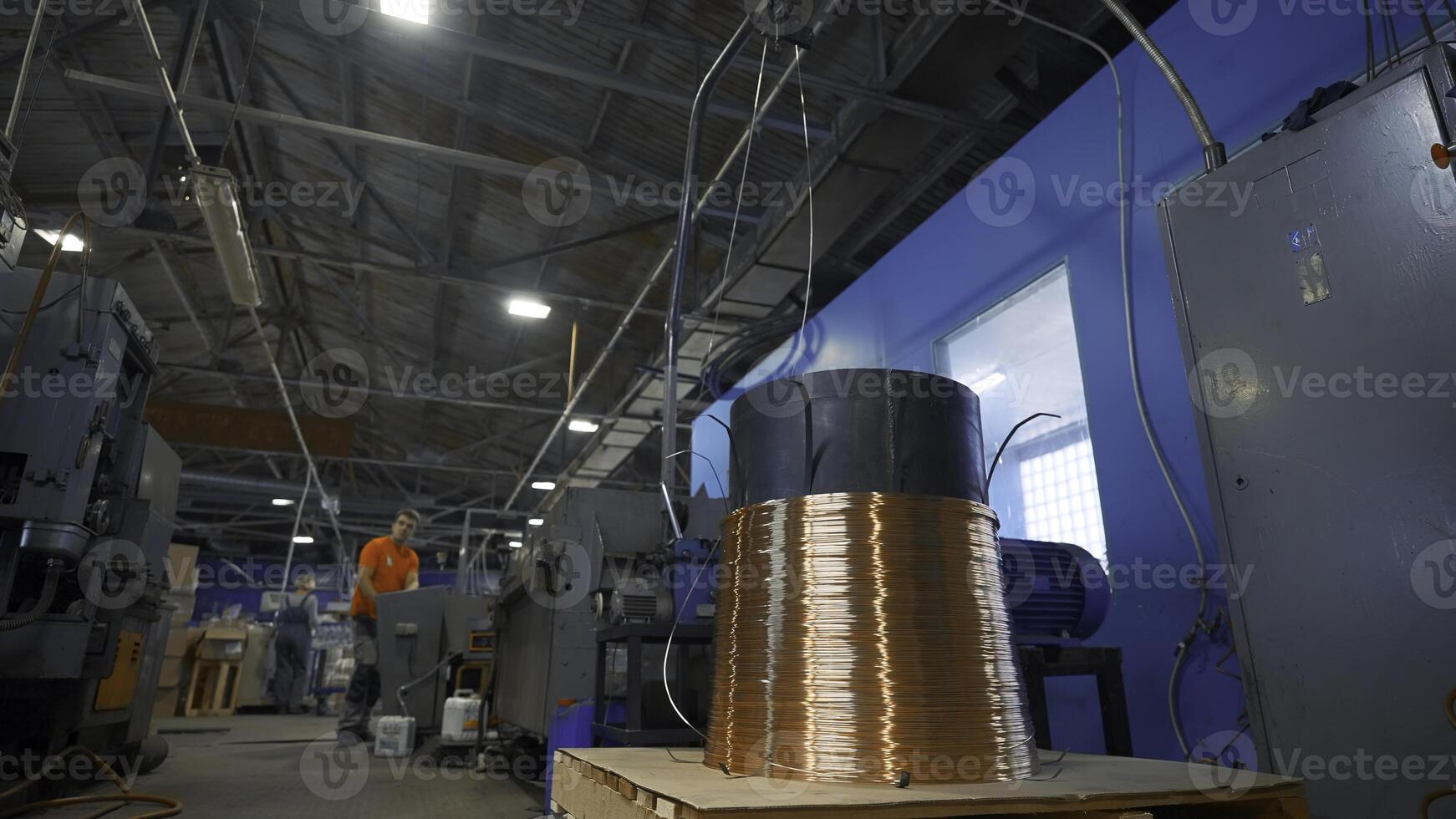 Copper wire on industrial coil with working. Creative. Worker adjusts operation of industrial machines on control panel. Industrial settings of machines with copper wires photo