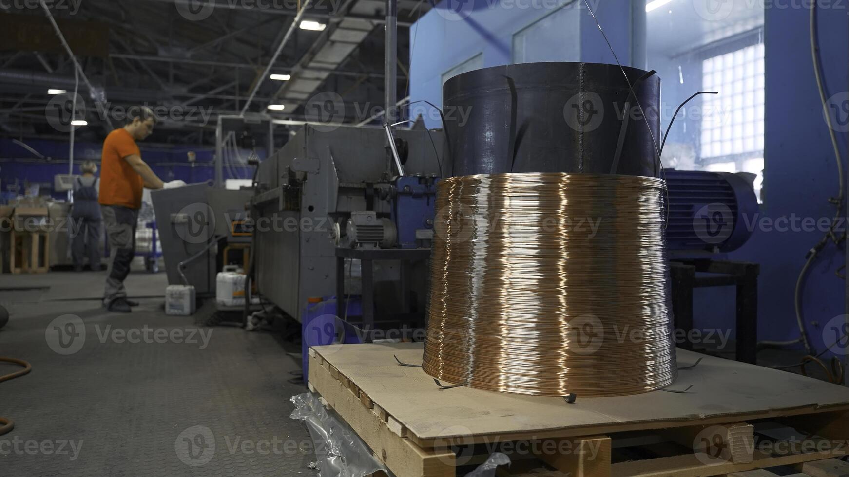 Copper wire on industrial coil with working. Creative. Worker adjusts operation of industrial machines on control panel. Industrial settings of machines with copper wires photo