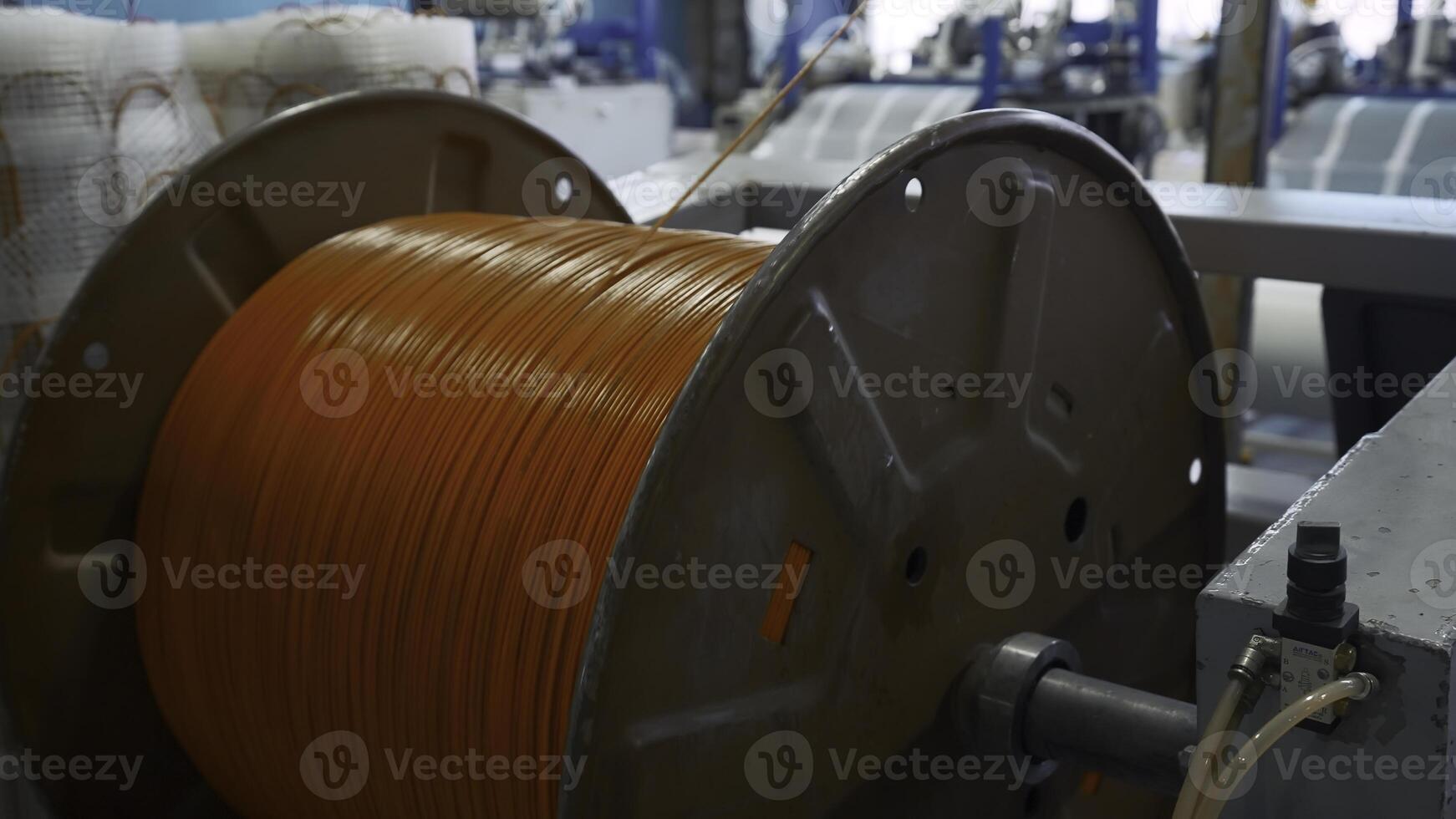 Spinning reel with rubber wire. Creative. Unwinding coil with rubber wire for insulation. Industrial production with rubber wires photo