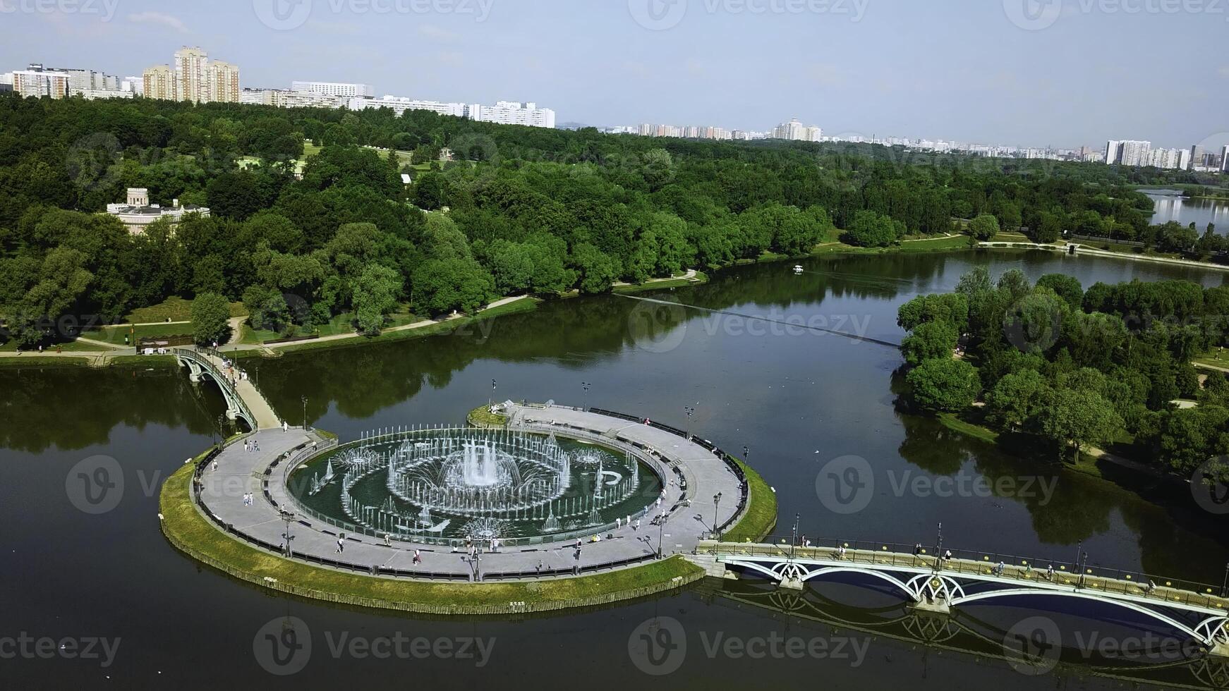 Top view of bridges in city pond with fountains. Creative. Island with bridges and fountains in city pond. Beautiful fountain complex on river island with pedestrian bridges photo