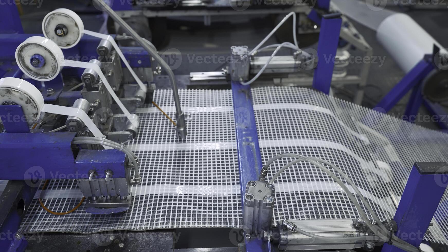 Automated Polymer Mesh Machine. Creative. Machines laying heating wires on polymer grid. Industrial production of modules for floor heating photo