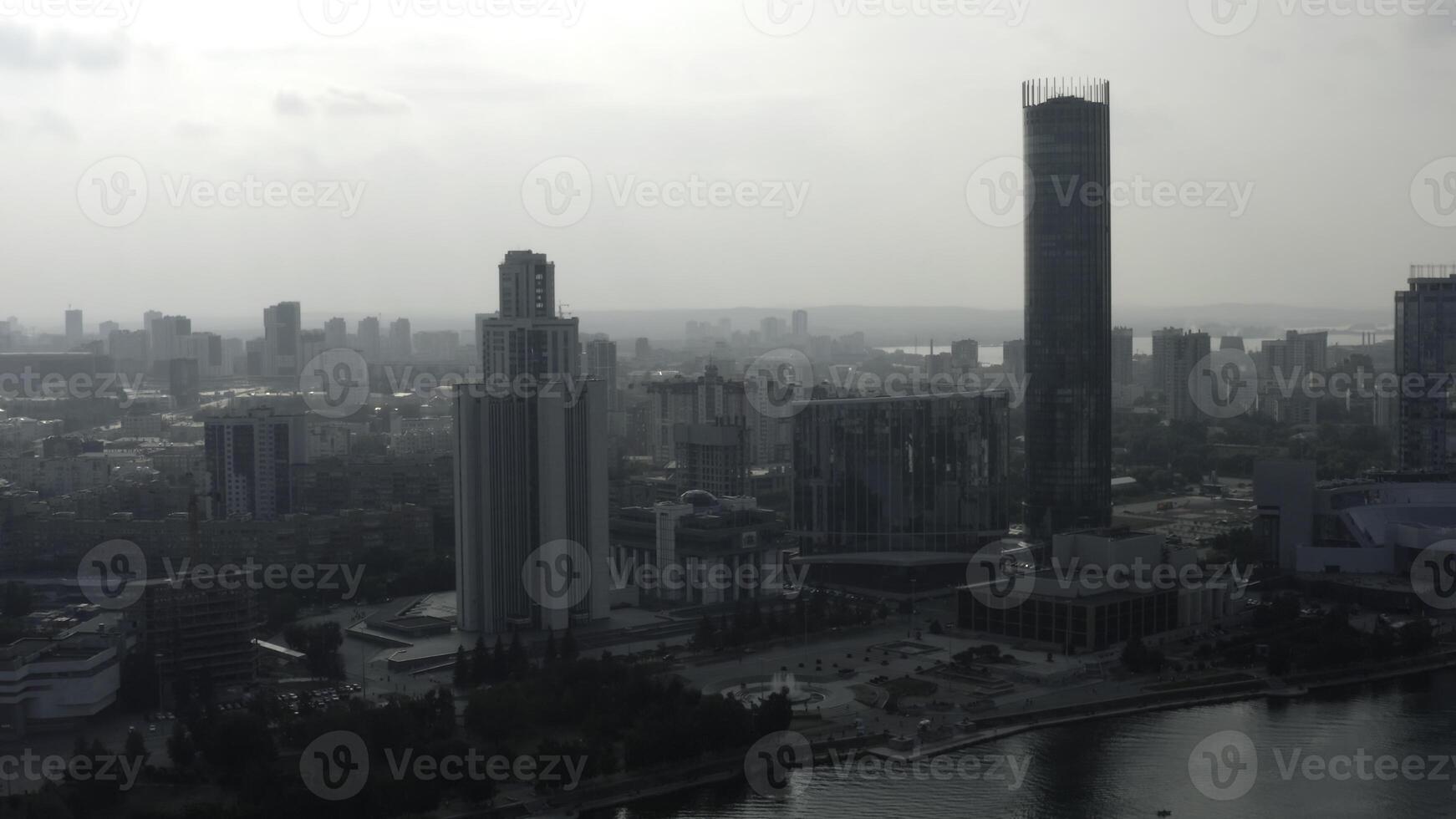 Top view of modern gray city in cloudy weather. Stock footage. Grey cloudy city with river and fog. Cloudy day hanging over modern city photo