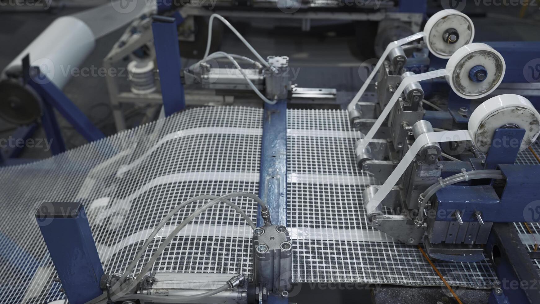 Automated Polymer Mesh Machine. Creative. Machines laying heating wires on polymer grid. Industrial production of modules for floor heating photo