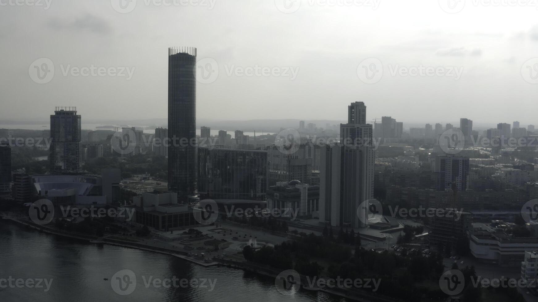 Top view of modern gray city in cloudy weather. Stock footage. Grey cloudy city with river and fog. Cloudy day hanging over modern city photo