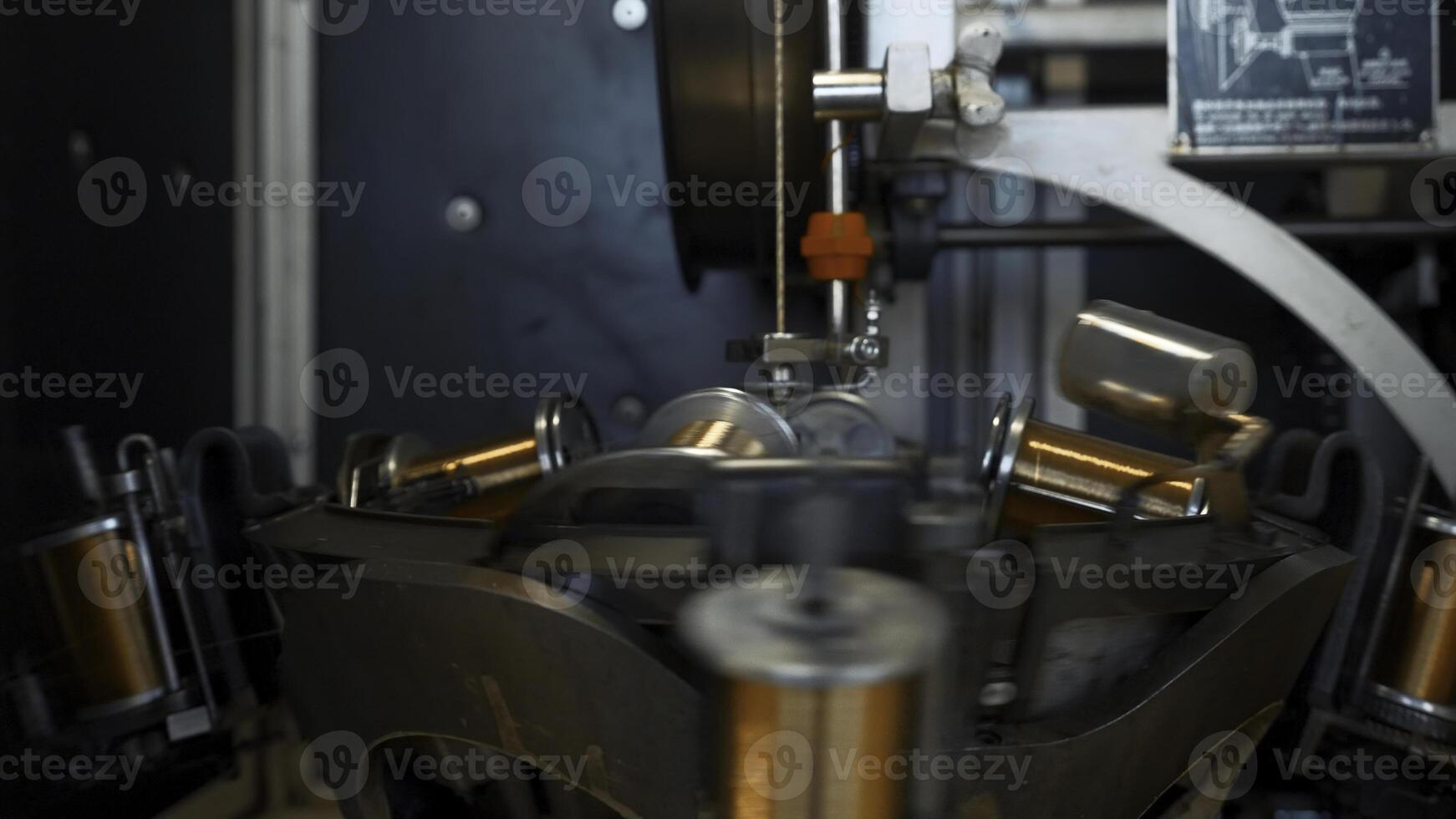 Automated machine with rotating coils and wire. Creative. Coils rotate on stack with winding wire. Industrial machine rotates and winds copper wire photo