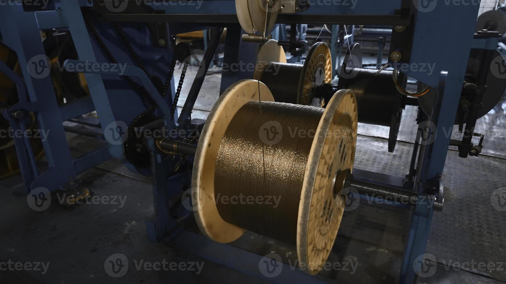 Industrial Machine for winding copper wire on coils. Creative. Automated production of metallurgical plant with swirling copper wires. Winding of copper wire on bobbins of industrial machine photo