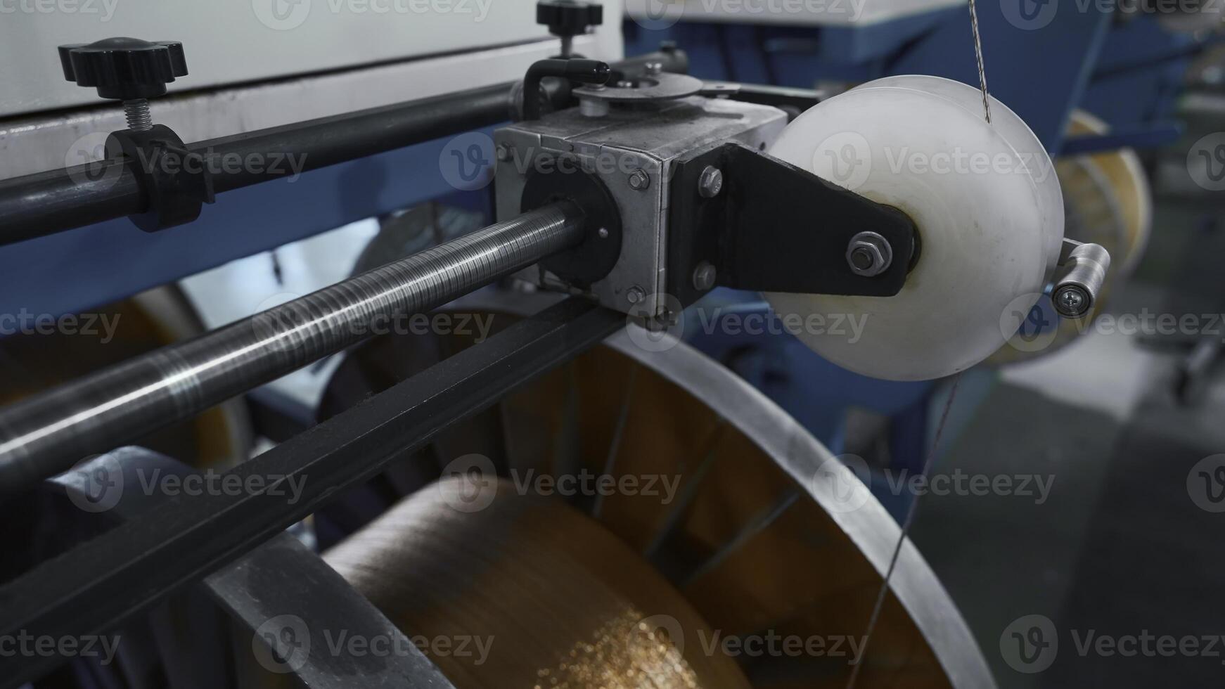 Industrial Machine for winding copper wire on coils. Creative. Automated production of metallurgical plant with swirling copper wires. Winding of copper wire on bobbins of industrial machine photo