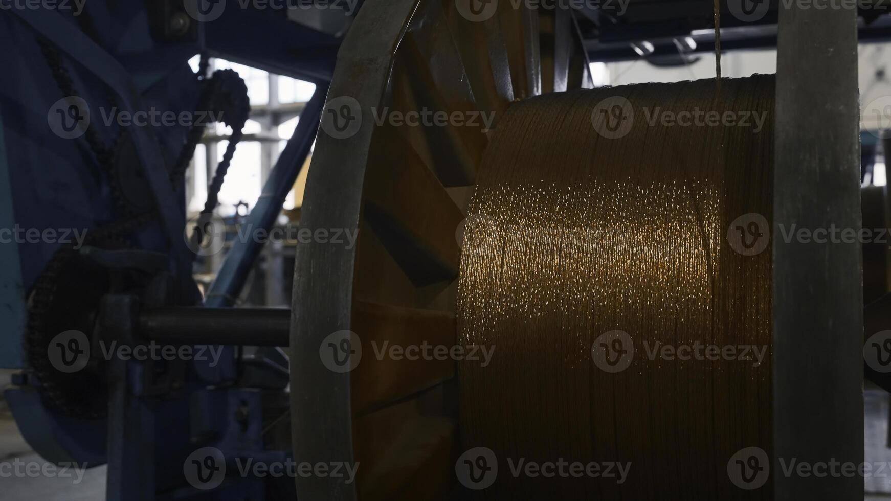 Rotating coils with metal wires at factory. Creative. Winding of metal fiber on bobbins at metallurgical plant. Process of twisting into coils of copper wire on industrial scale photo