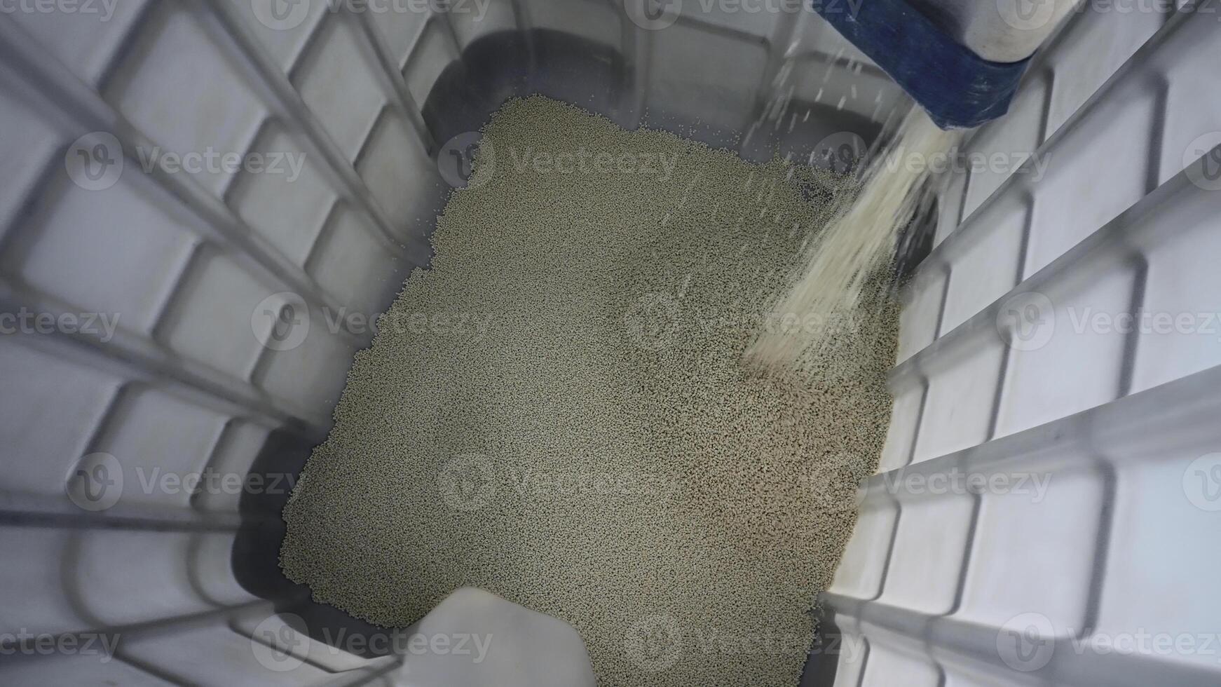 Pouring pile of plastic particles. Creative. Process of filling containers and cleaning plastic particles. Plant for processing chemical granules of plastic photo