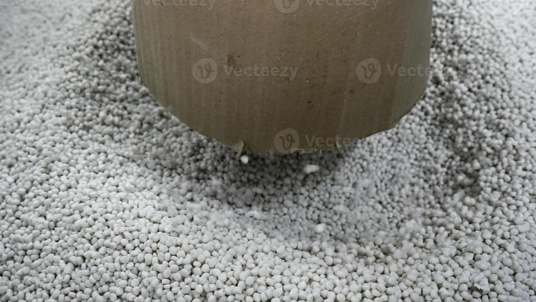 Close-up of polymer granules in production. Creative. Process of extrusion and drying of plastic granules. Pile of white plastic pellets in industrial workshop photo