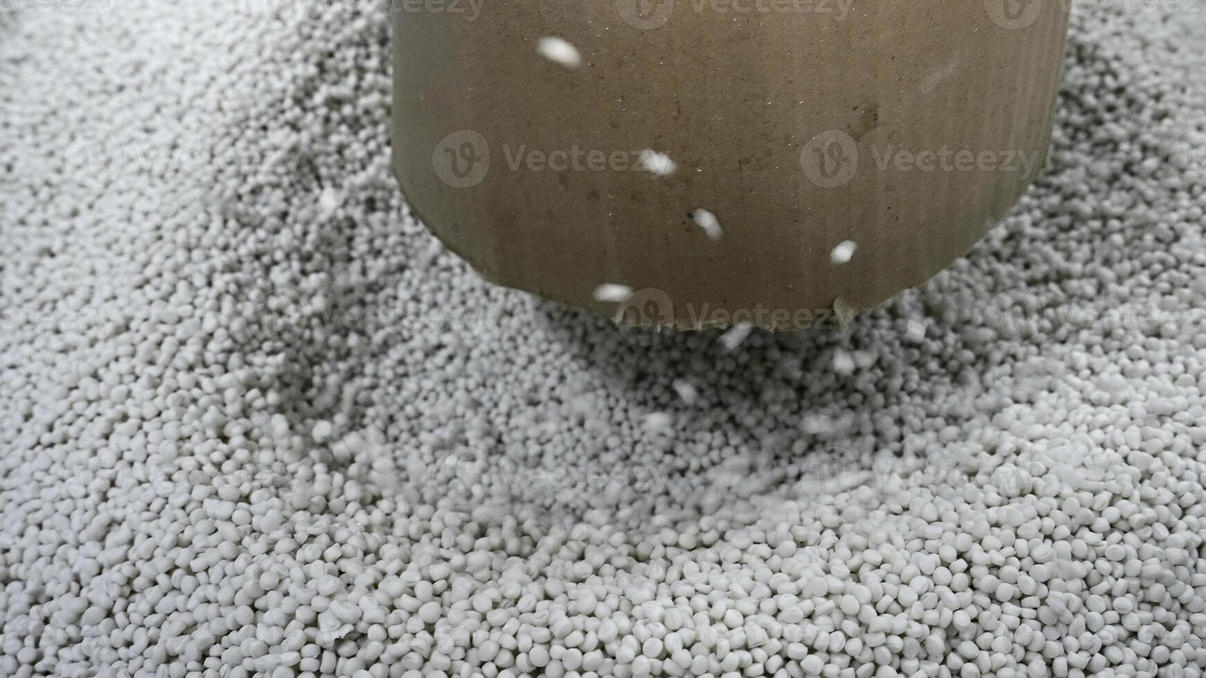 Close-up of polymer granules in production. Creative. Process of extrusion and drying of plastic granules. Pile of white plastic pellets in industrial workshop photo