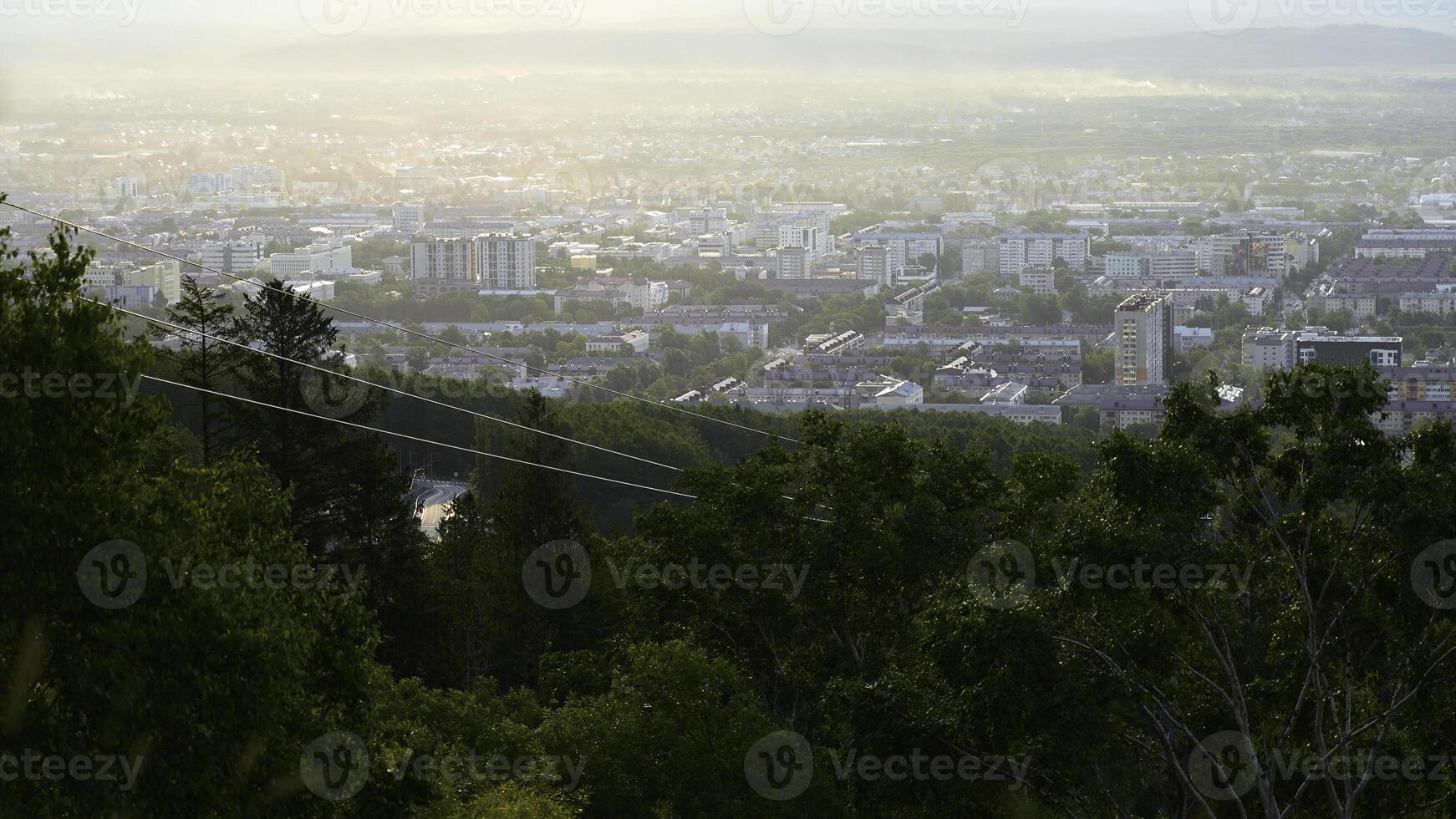 hermosa ver de cable coche con ver de pueblo en verano. acortar. verde bosque en Pendiente con Moviente cable formas en borde de ciudad. hermosa ciudad en Valle con cable coche en soleado verano día foto