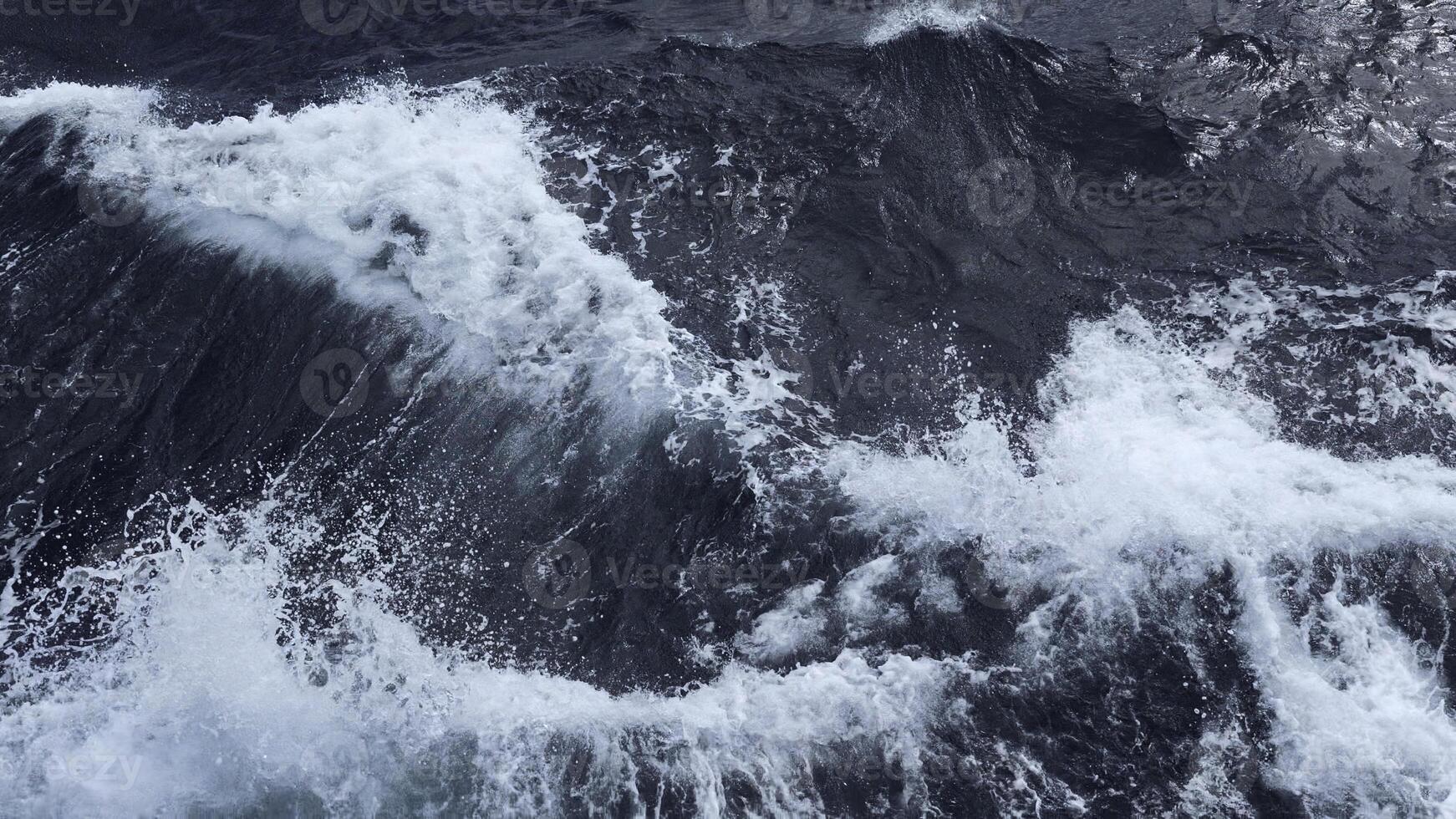 Beautiful waves from moving boat. Clip. Splashes of waves from moving sea boat. Beautiful waves moving sideways from floating boat in sea photo