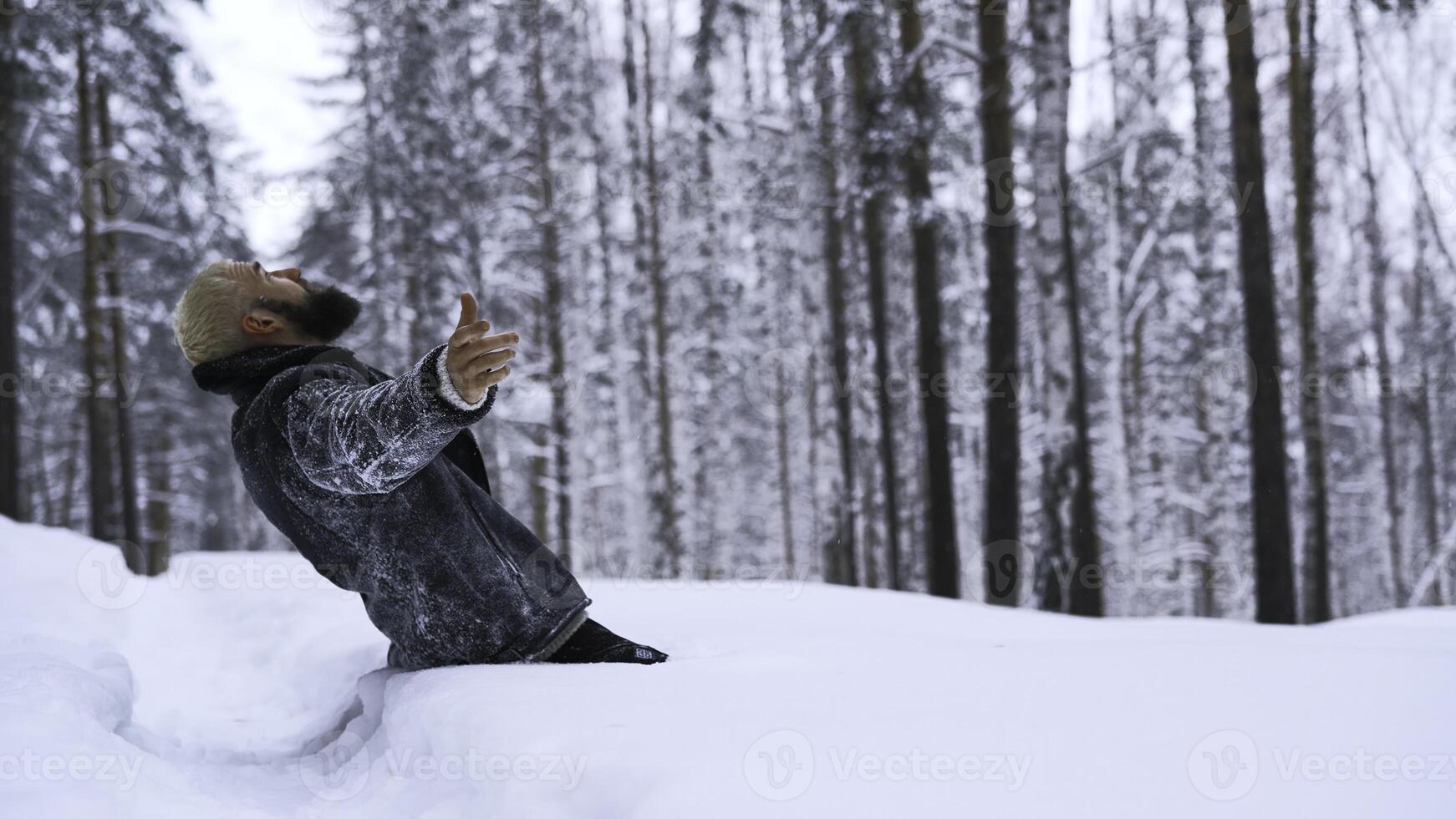 Man begs for help. Media. Lost man prays to God for help in winter forest. Man got lost in forest alone and begs for help on winter day photo