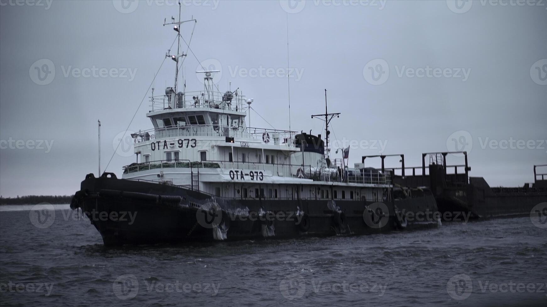 Beautiful sea vessel at pier in winter. Clip. Naval vessel with numbers and flag is preparing to sail at pier. Marine vessel at berth of north coast in winter photo