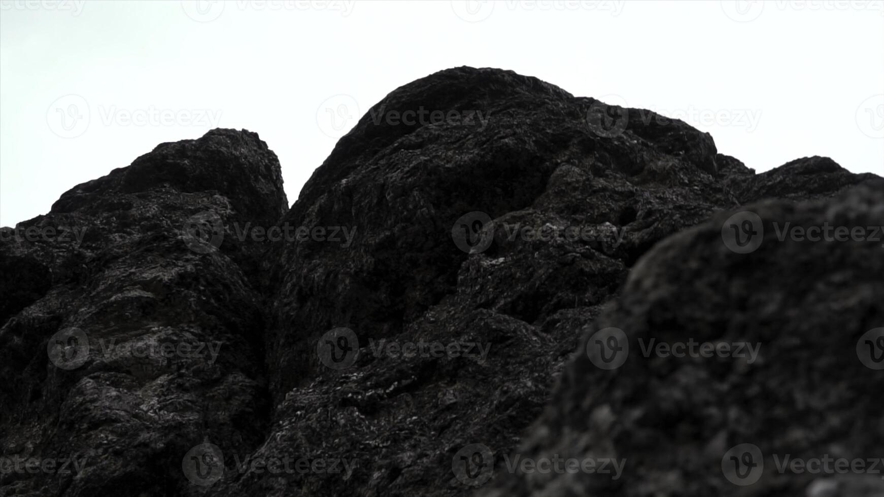 Giant rocks on cloudy sky background. Clip. Close up of grey stone texture. photo