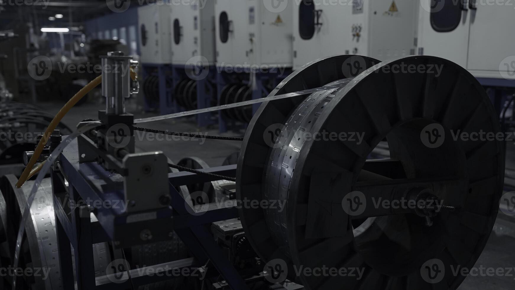 Close up of slowly rotating big bobbin with winding thin metal sheet. Creative. Industrial background at the plant. photo