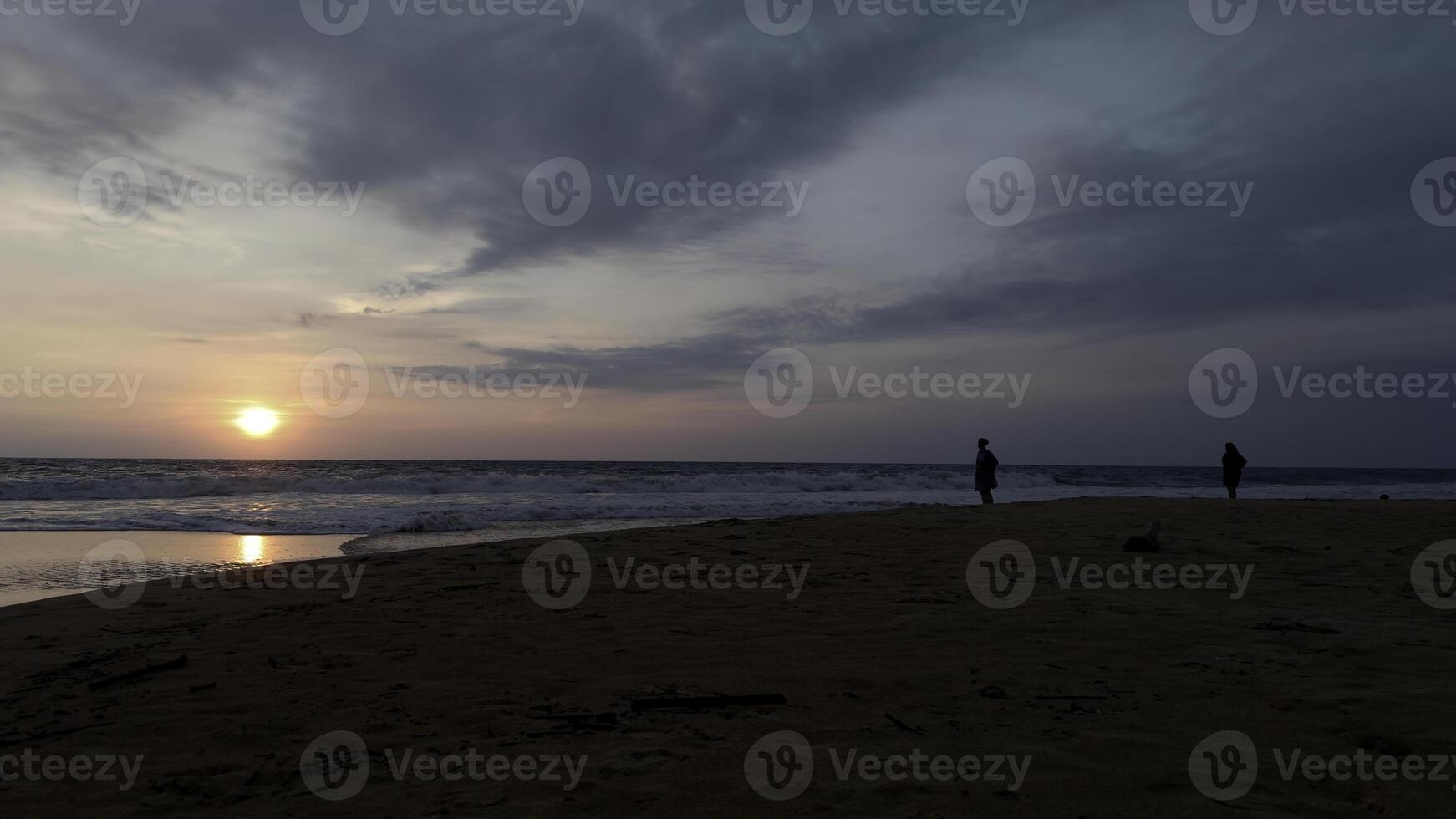 dramático mar amanecer en nublado cielo. acción. ondulado arena mar zapato y un Pareja reunión nuevo día. foto