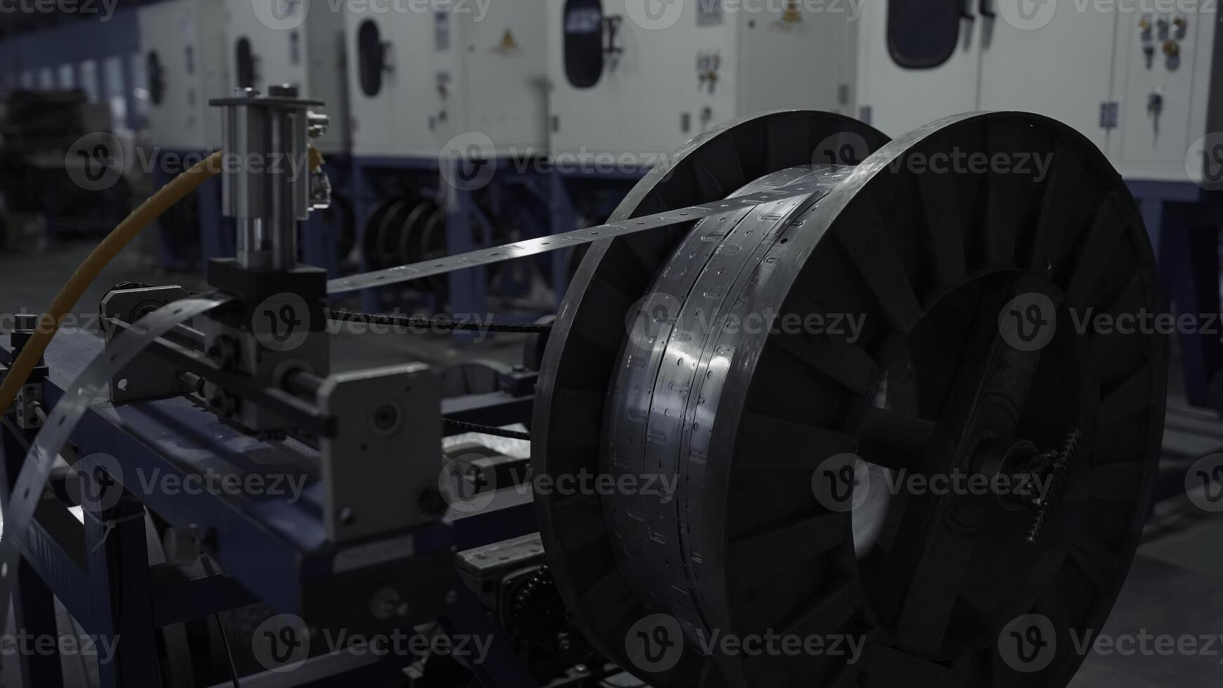 Metal long narrow sheets wraping on a bobbin. Creative. Large spool in a factory workshop, industrial background. photo