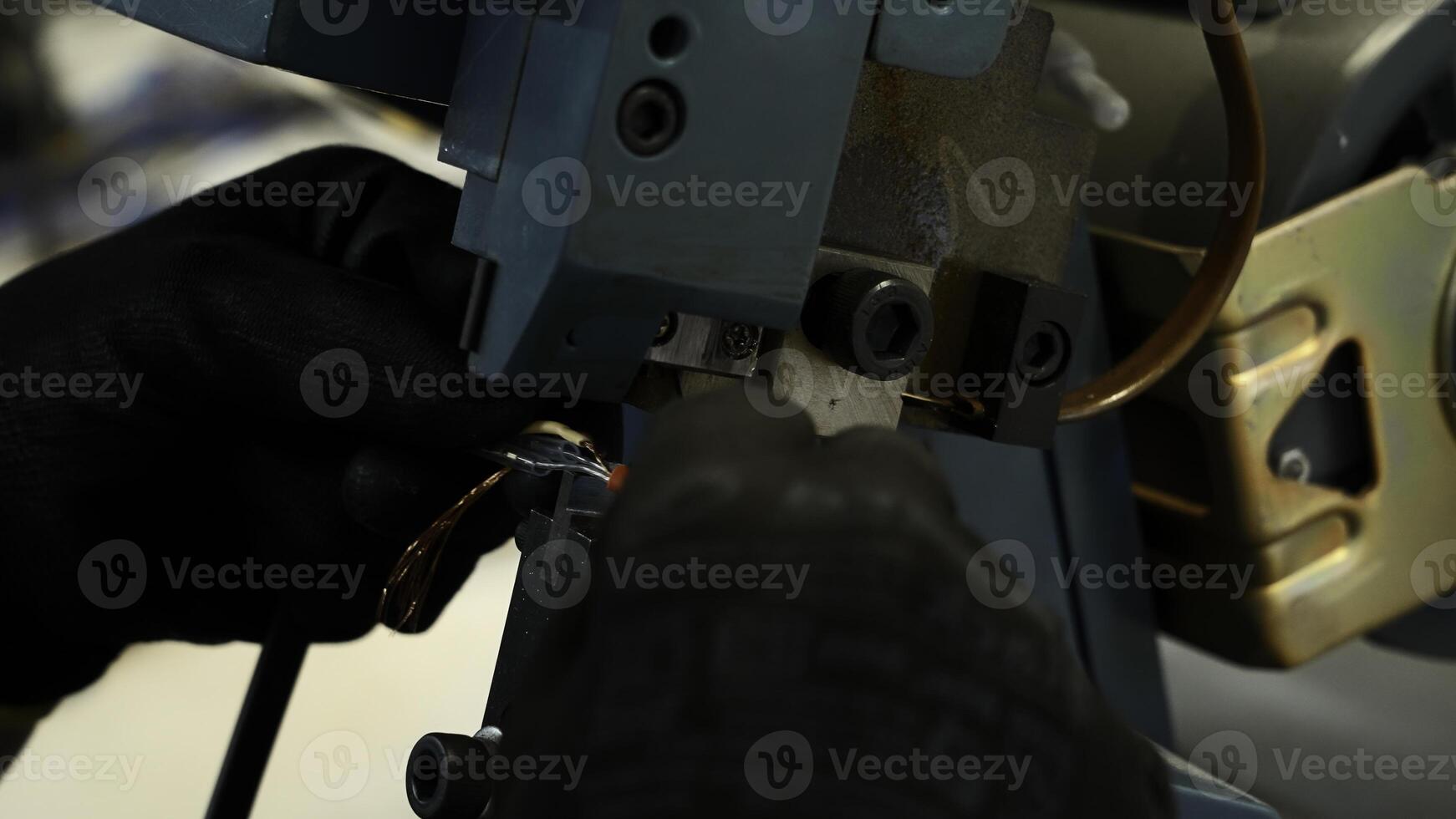 Close up of worker hands making a wire with a special machine. Creative. Industrial background at a factory workshop. photo