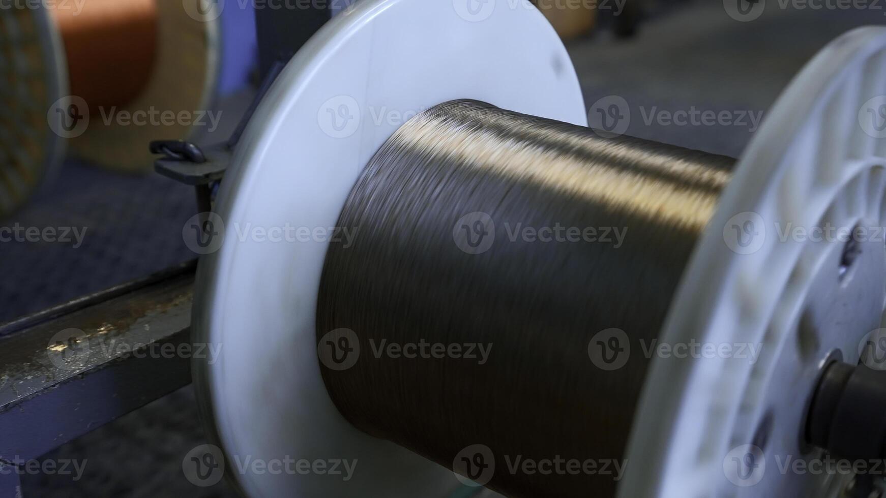 Close up of automated winding the cable on the drum. Creative. Industrial cable production factory. photo