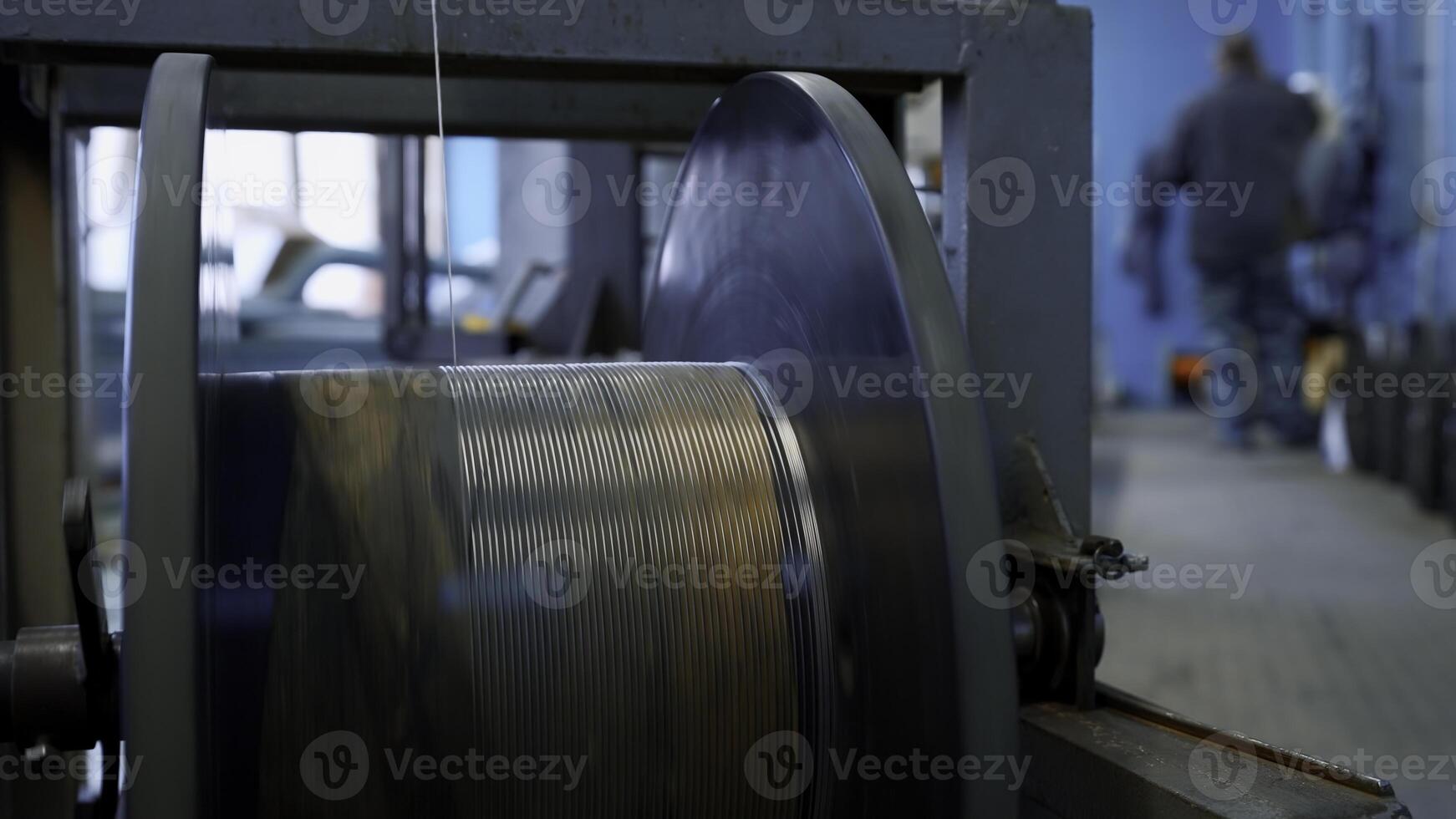 Close up of automated winding the cable on the drum. Creative. Industrial cable production factory. photo