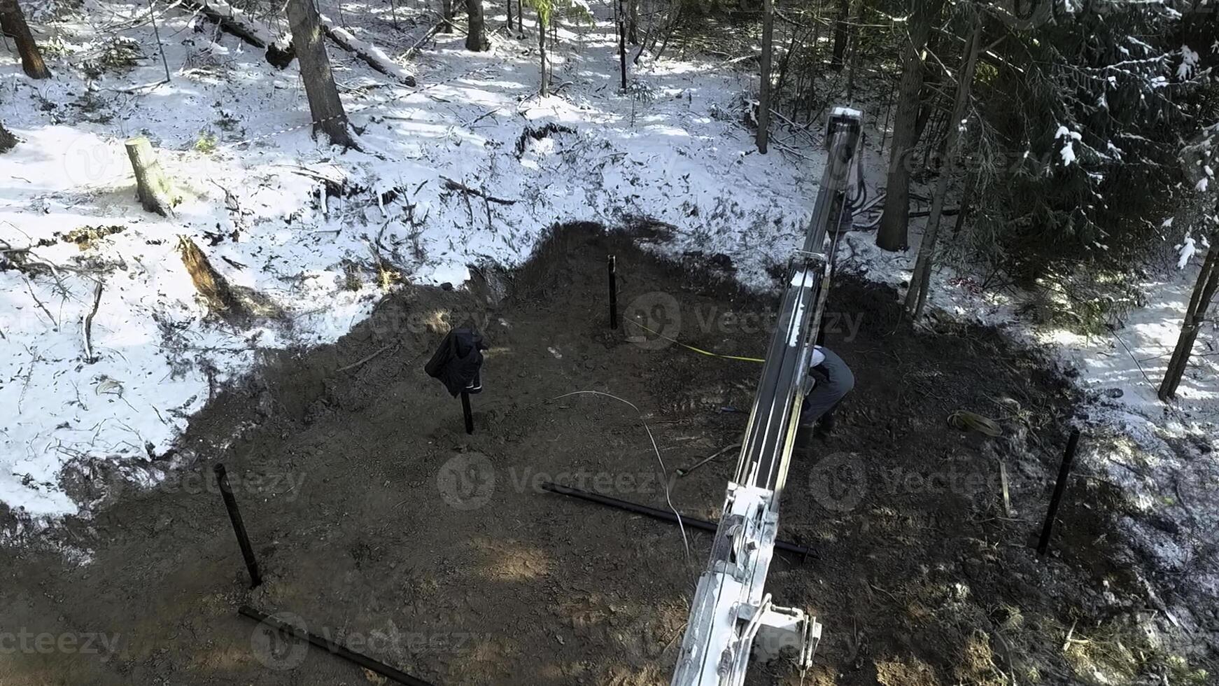 Work on a construction site during winter. Clip. Industrial background outdoors in winter forest. photo