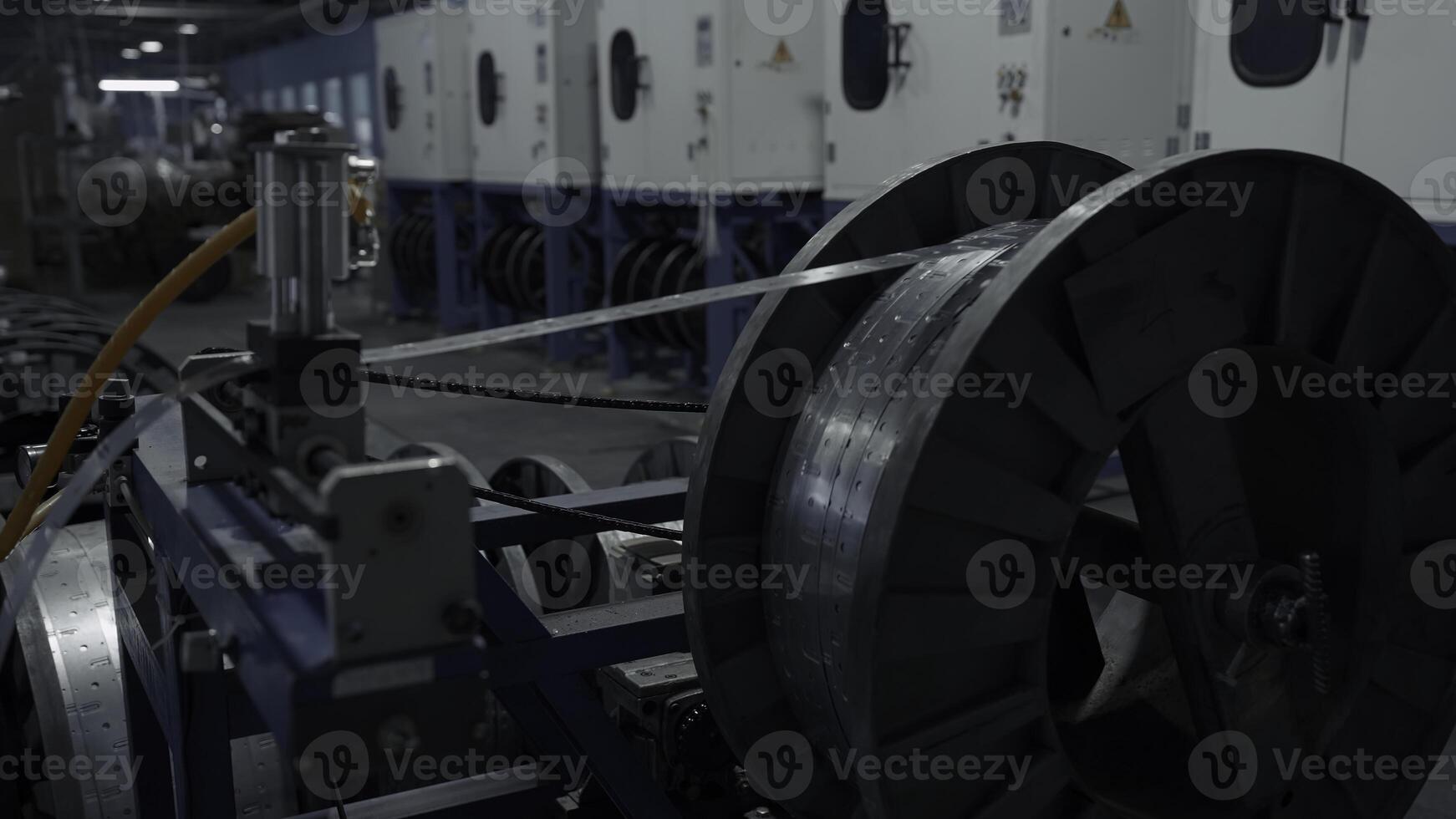 Metal long narrow sheets wraping on a bobbin. Creative. Large spool in a factory workshop, industrial background. photo