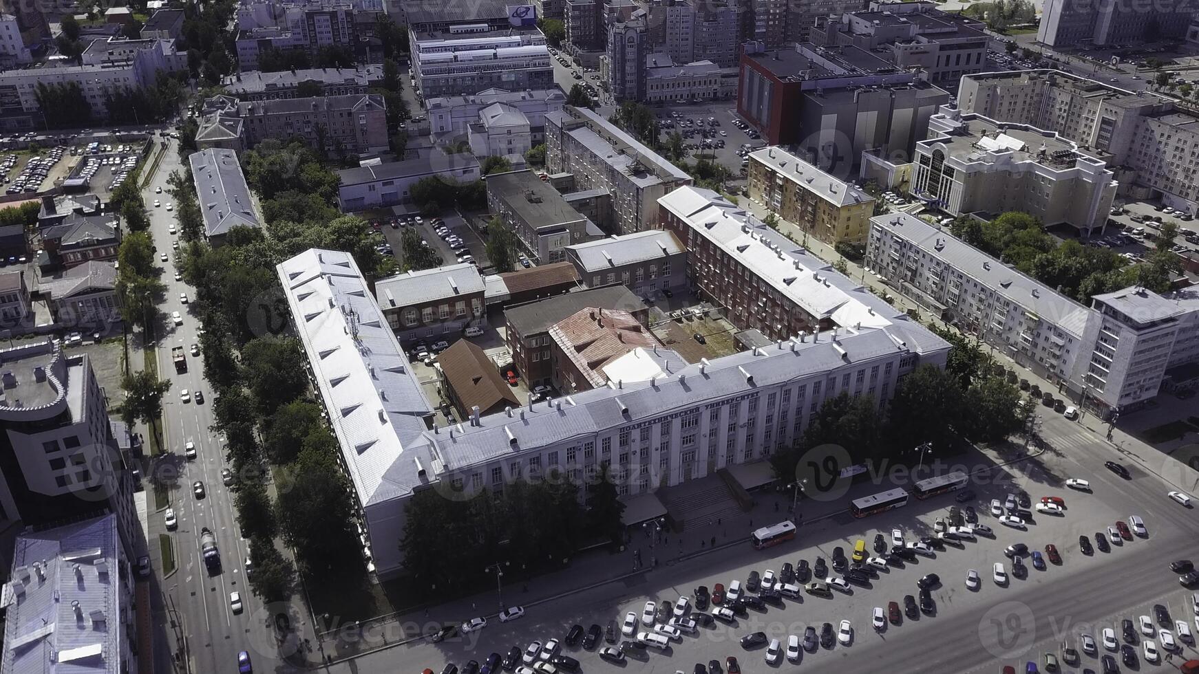 Aerial view of the avenue with developed infrastructure. Clip. Big city center with buildings, roads, trees, and many cars. photo