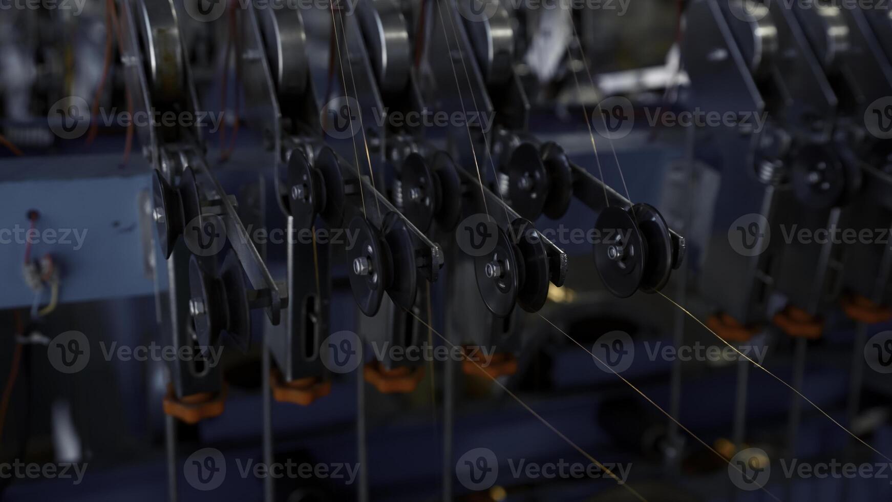 Close up of many small steel wire coils at the factory. Creative. Industrial background with thin wires stretching from the spinning spools. photo