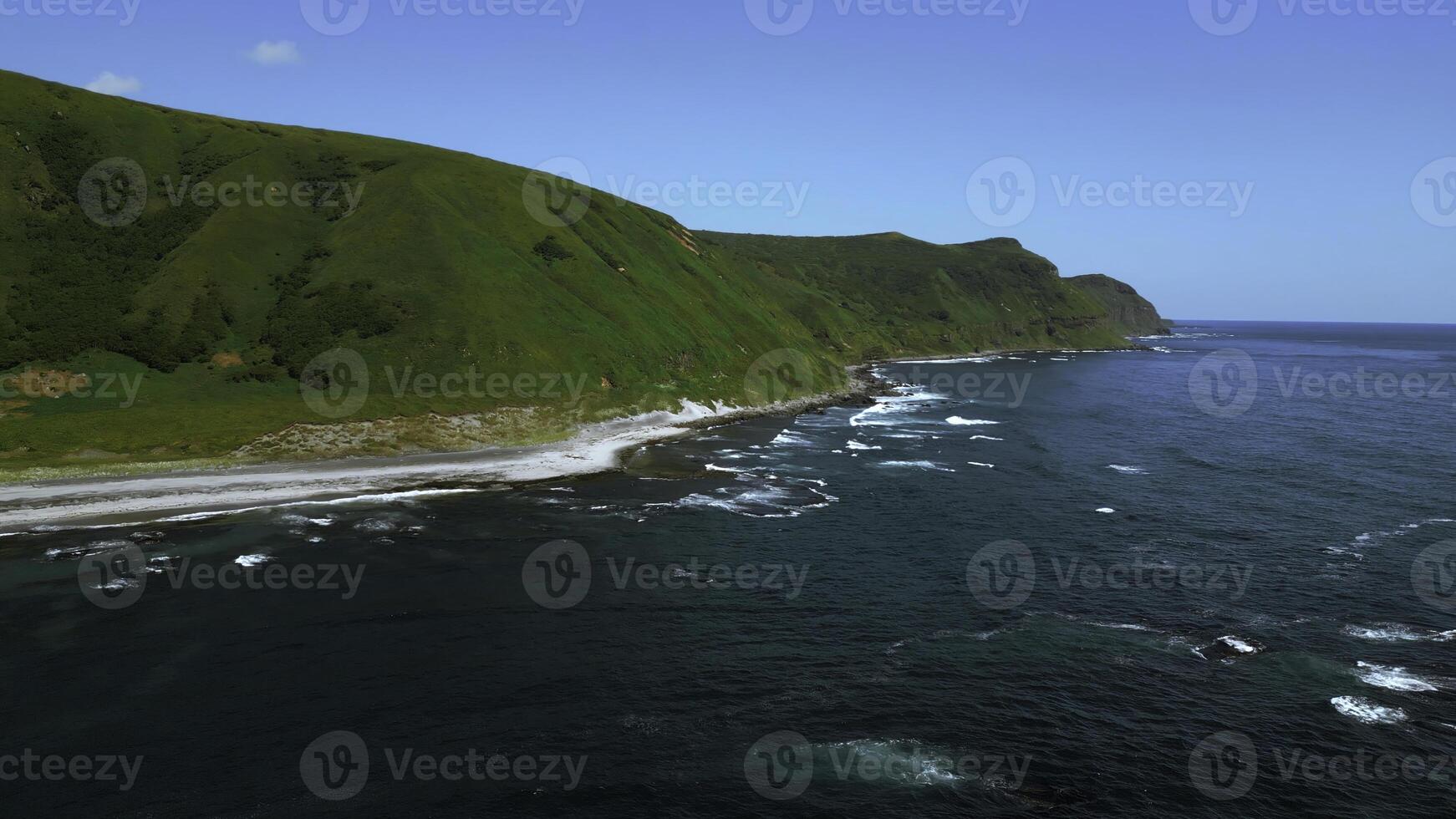 Breathtaking aerial view of the summer beach coastline. Clip. Wild empty sea shore and green fields. photo