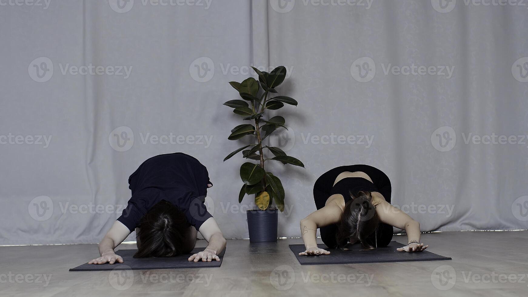 Young man and woman doing yoga on mats. Media. Concept of sport and body care. photo