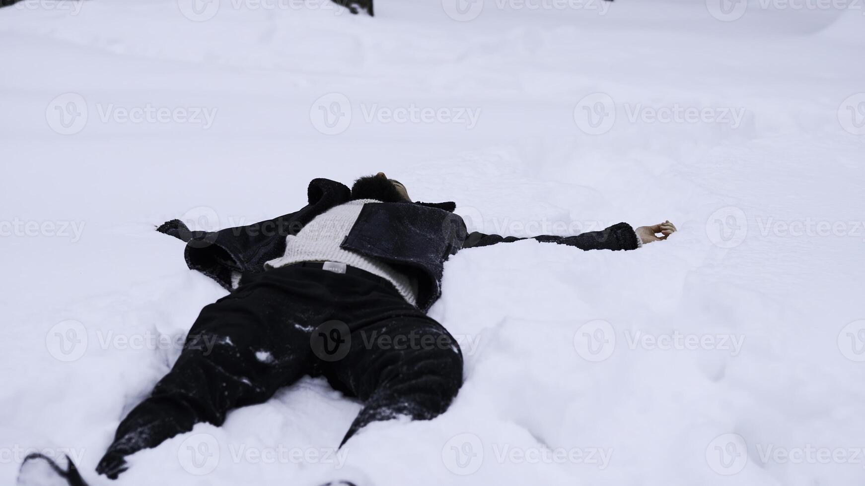 Happy young man in fairytale winter forest lying on snow. Media. Concept of religion and feeling unity with nature. photo