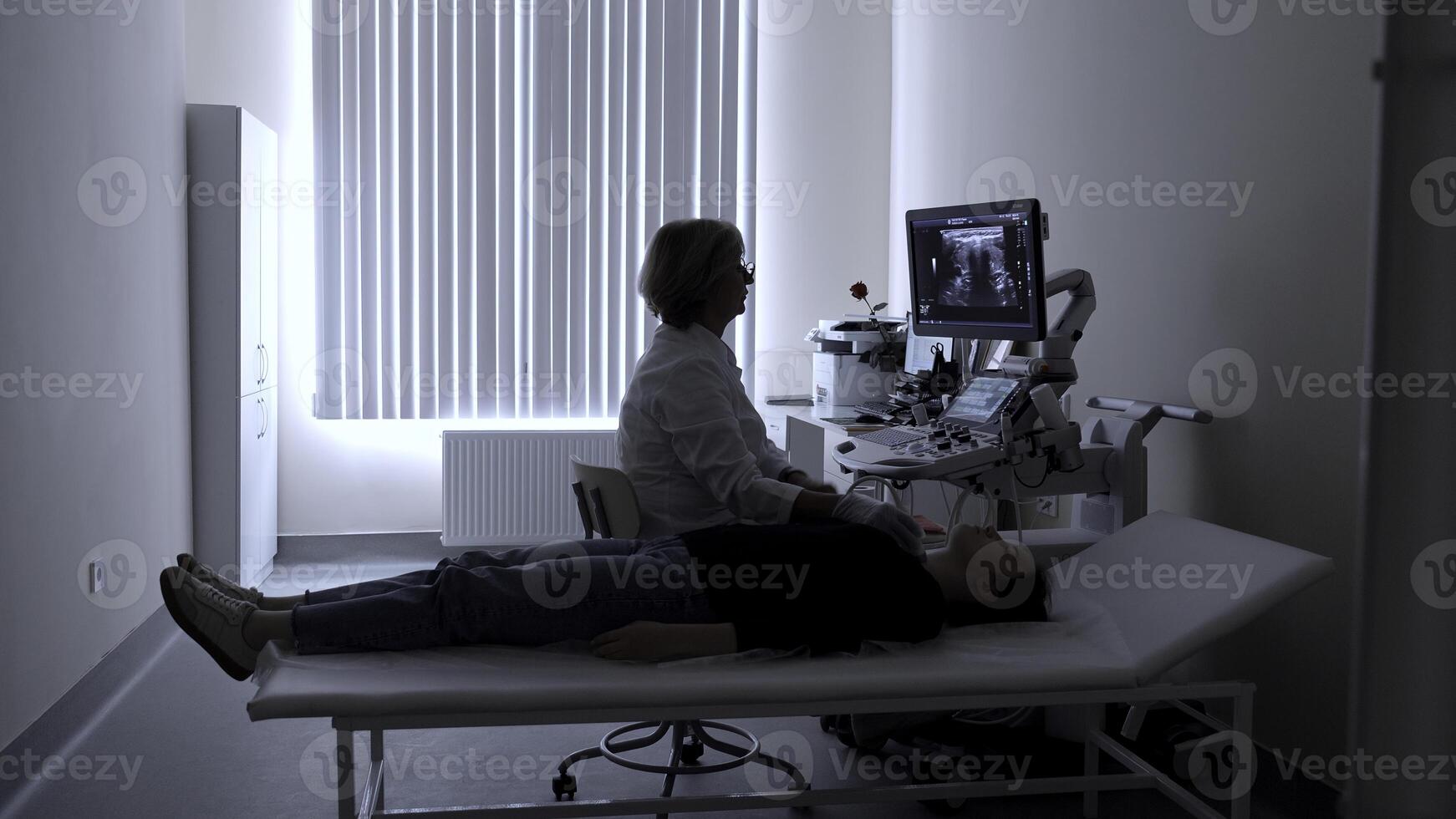 Ultrasound diagnosis of the thyroid gland of a young woman in the clinic. Clip. A female doctor holds an ultrasound probe. photo