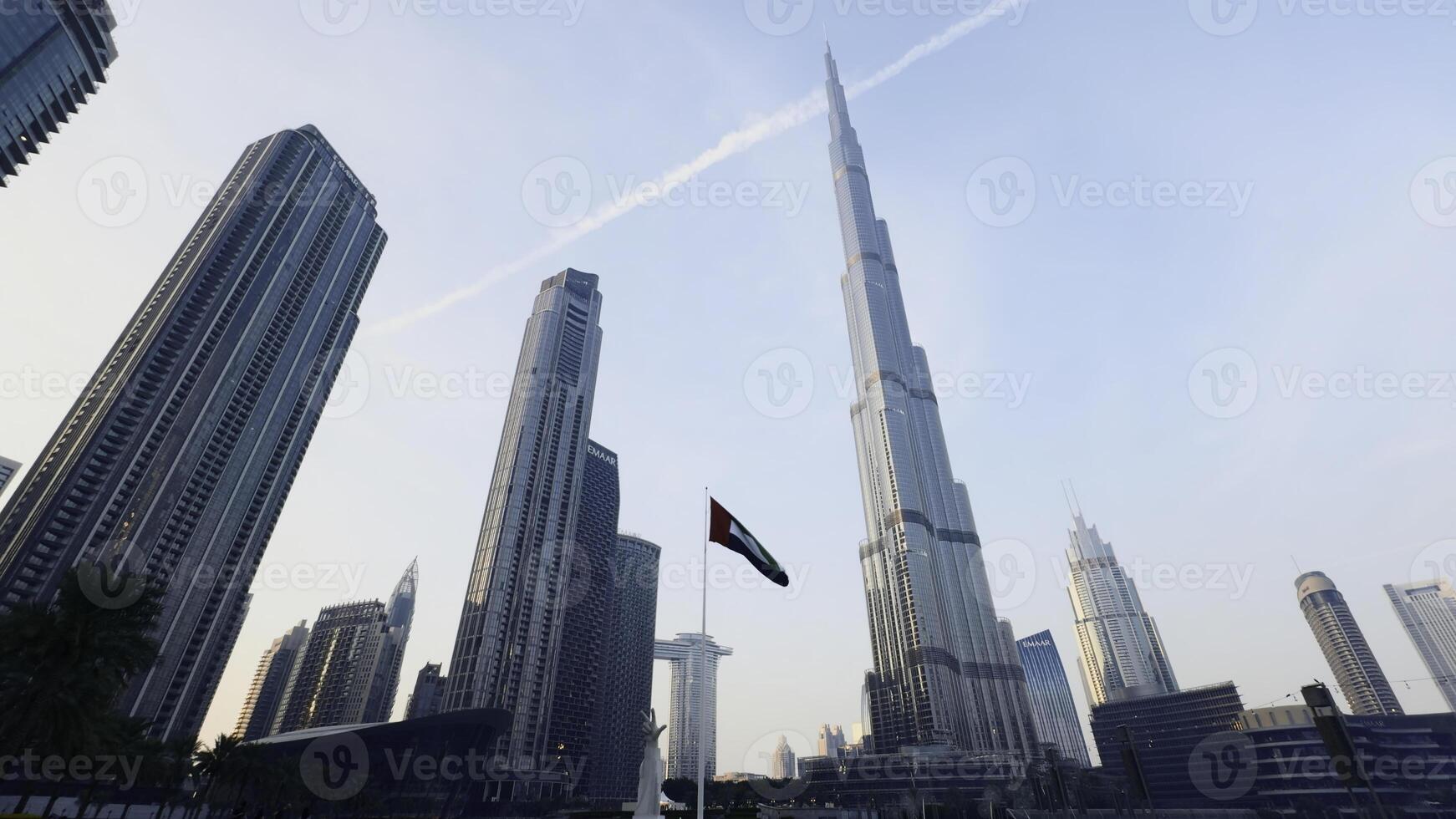 Burj Khalifa at Dubai Mall in UAE, famous landmark. Action. Low angle view of a skyscraper and palm trees. photo