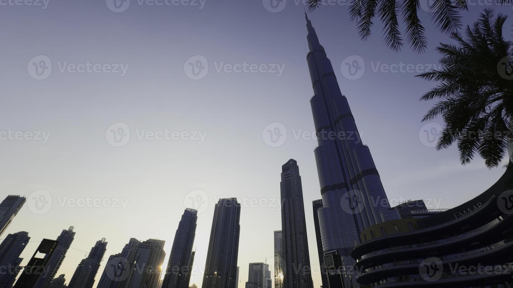 Low angle view of Burj Khalifa with blue sky behind. Action. Modern glass facade skyscraper in the city center. photo